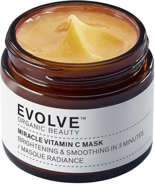 En brun burk med vit etiket, öppen för att visa gul kräm inuti. Etiketten säger "Evolve Organic Beauty" och "Vitamin C Mask."