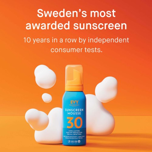 A blue spray bottle of sunscreen with the number 30 on it, surrounded by white foam and bubbles, on an orange background.