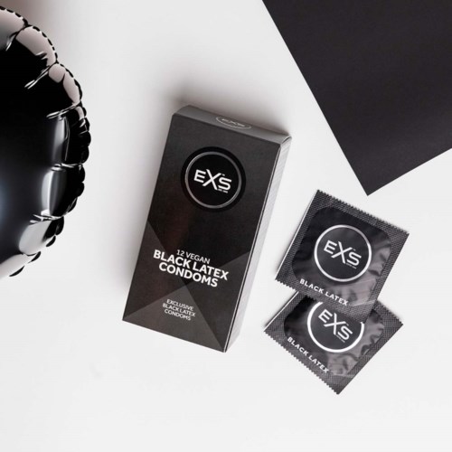 Schwarze Latex-Kondomverpackung mit zwei Kondomen und einem schwarzen Folienballon in der Nähe.