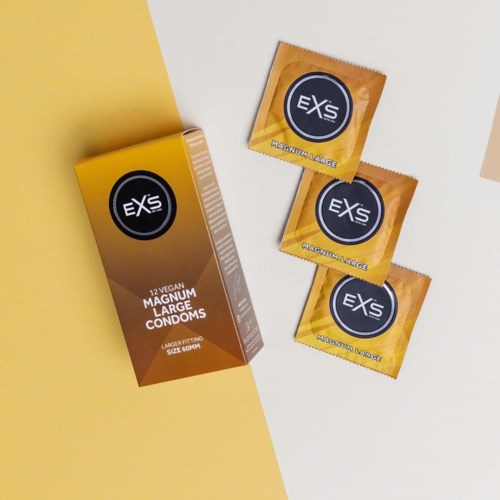 Schachtel und drei gelbe Kondompacks mit schwarzem und weißem Label, die große Größe und vegane Inhaltsstoffe anzeigen.