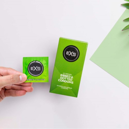 Grüne Box mit EXS gerippten und gepunkteten Kondomen, drei Kondome außerhalb der Verpackung, fördert Komfort und Sicherheit.
