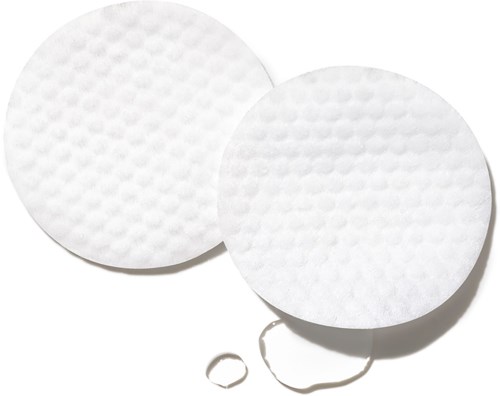 Zwei runde weiße Pads mit strukturierten Oberflächen sind zu sehen, mit einem kleinen Gummiband in der Nähe.