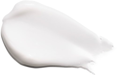 Eine weiße Creme oder Lotion breitgestellt, glatt und glänzend, vor dunklem Hintergrund.