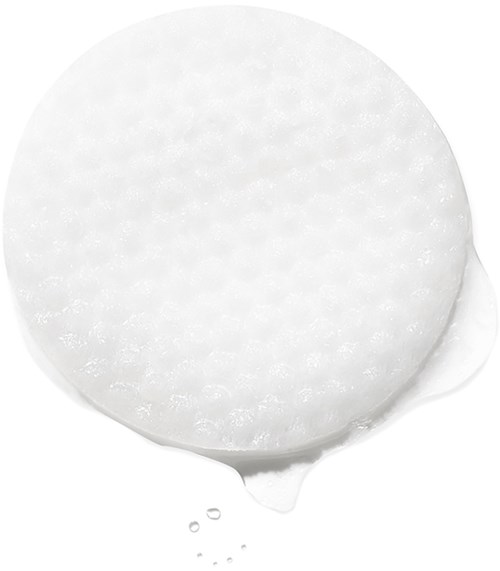 Ein runder weißer Wattepads mit einigen Tropfen, die herunterlaufen.