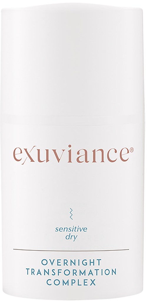 Een witte fles met bruine en blauwe tekst, gelabeld 'exuviance,' 'sensitive dry,' en 'overnight transformation complex.'