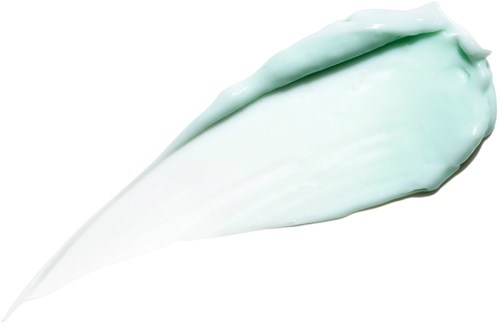 Een lichtgroene crème met een gladde, zachte textuur, uitgesmeerd op een witte achtergrond.