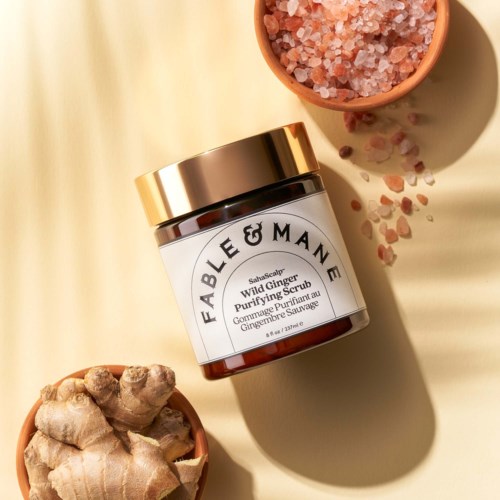 En burk med Fable & Mane Wild Ginger Purifying Scrub med ingefära och pink Himalayasalt runt omkring.