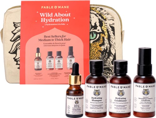 Ett set med Fable & Mane hårprodukter inklusive schampo, balsam, leave-in-behandling och en liten flaska med pipett, framför en tigeransiktsdesignad väska.