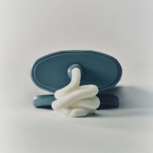 Een blauwe zeepbakje met een witte zeep en een wit romig vlekje er voor.