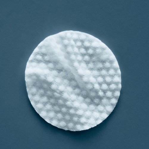 Een ronde watje met een getextureerde oppervlakte op een donkere achtergrond.