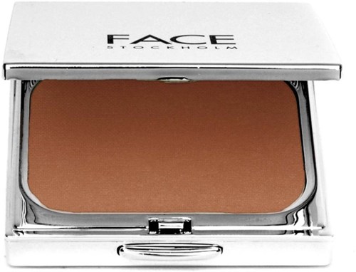 Een make-up compact met een bruine poeder en een witte uitschuifbare deksel met zwarte tekst.