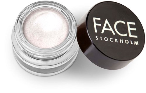En liten rund behållare med vit kräm och ett svart lock med texten 'FACE STOCKHOLM'.