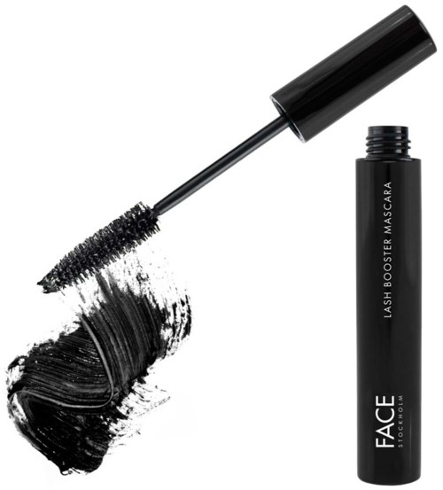 Een zwarte mascara-flacon met kwast, met de applicator en smudges mascara op een witte achtergrond.
