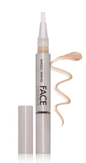 Een witte make-upstiftachtige pen met een beige vloeistof ernaast.