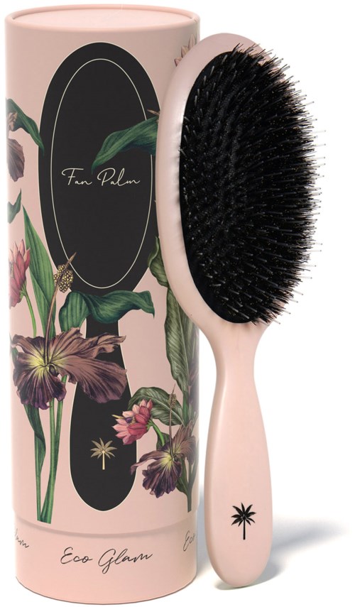 A hairbrush with a floral design on its handle, next to a cylindrical box with a similar floral wrapping.