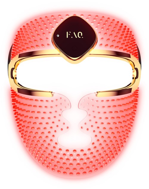 A pink facial mask with small bumps, gold accents, and a label marked "FAC" at the center.