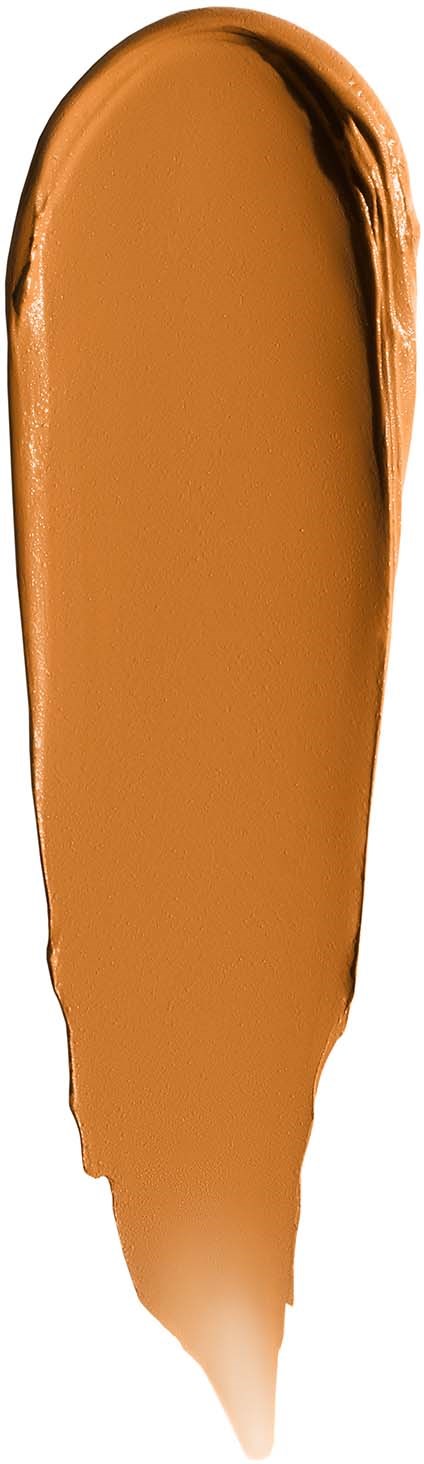 A swatch of light brown makeup or face paint with a smooth, creamy texture on a vertical surface.