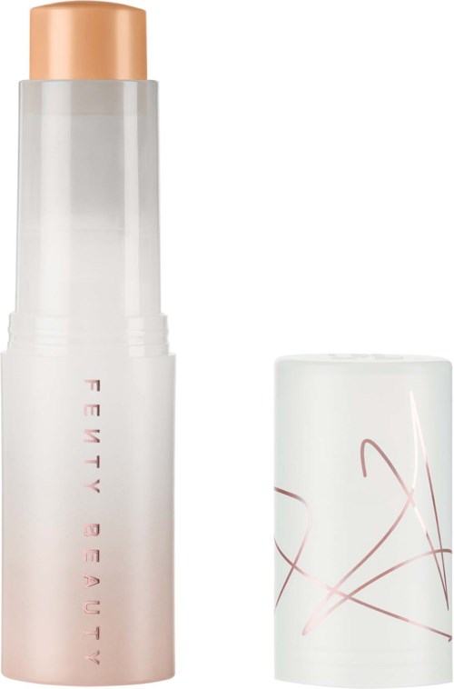 A cosmetic stick with a beige cap and a mostly white body with pink text and lines.