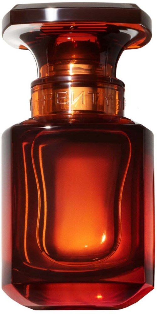 A small, round, amber-colored glass bottle with a wide, flat top. It has a shiny, smooth surface.