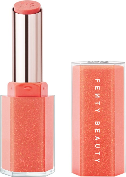 Lipstick in a pink shade, with the cap removed, revealing the product. Packaging says "Fenty Beauty."