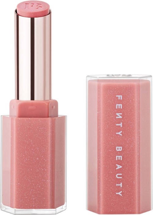 A lipstick in a pink case with 'Fenty Beauty' written on the side, partially open showing the lipstick stick.
