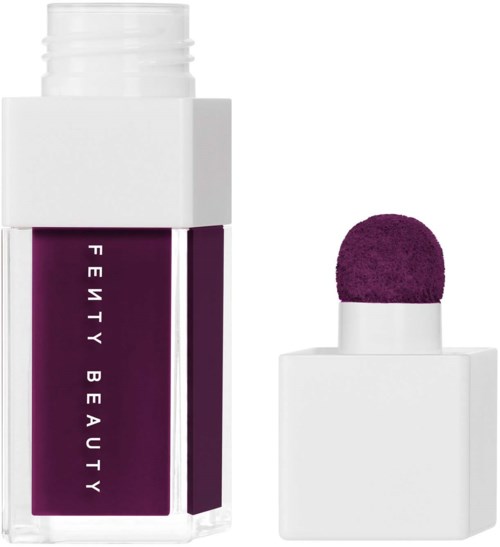 A bottle with purple and white colors, featuring a purple makeup applicator sponge.