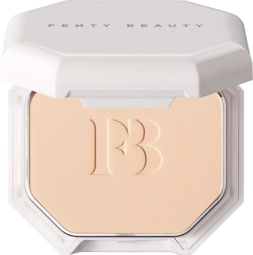 A compact with beige powder and a lid that has Fenty Beauty written on it.