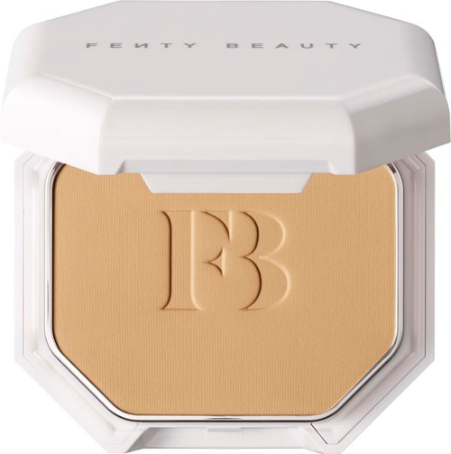 A compact makeup foundation with a white lid and the letter 'B' embossed on the beige powder.