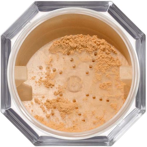 Light brown powder inside a round container with holes, possibly a makeup or cosmetic product.