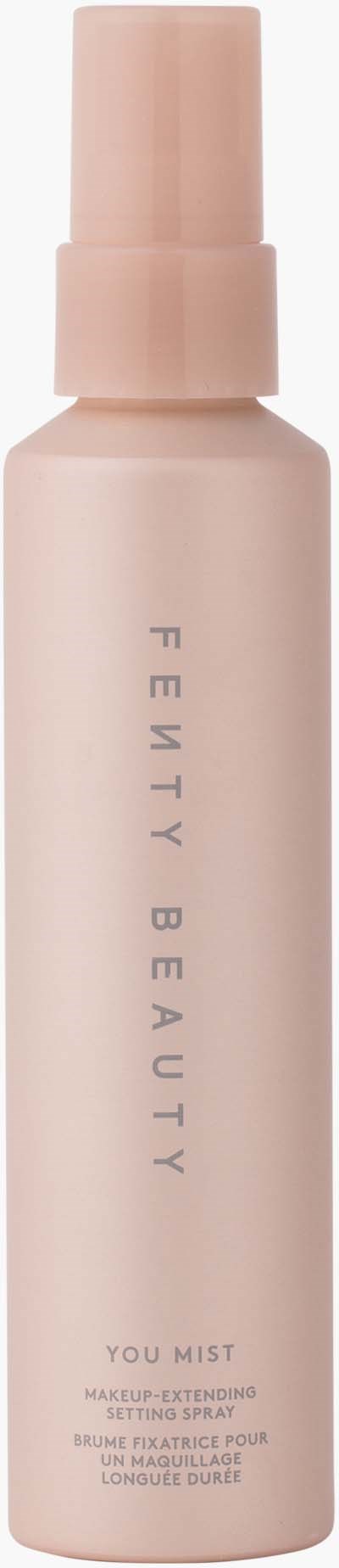 A pink cylindrical spray bottle with a cap, labeled 'Fenty Beauty, You Mist' for makeup setting.