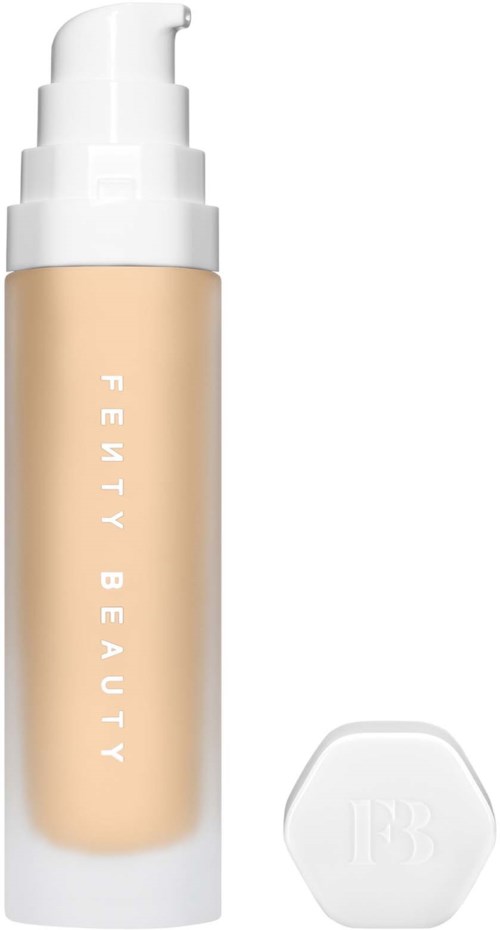 Ett beige pumpflaska med orden 'Fenty Beauty' och en vit kork, bredvid en vit svampapputrustning.