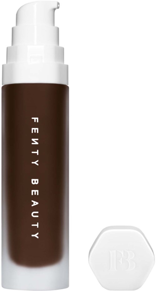 En brunn flaska med vit pump och lock, märkt 'Fenty Beauty', bredvid en vit hexagonformad applikator.