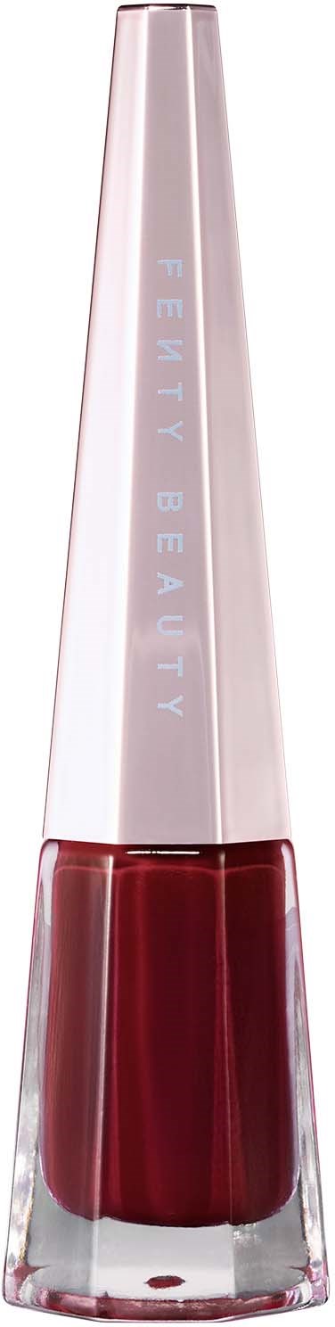 A tall, slim nail polish bottle with a metallic lid. Label says "Fenty Beauty". Red nail polish visible inside.