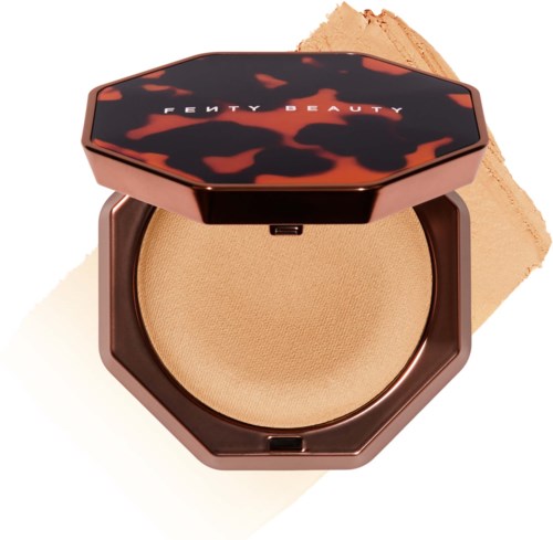 En kompakt, öppen makeup puder med en sköldpadds-shell lock och ett beige puder inuti.