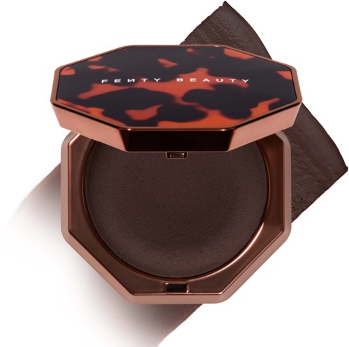 En rund ögonskugga med mörkt sköldpadds-d Nautic på locket. Fenty Beauty-logga på toppen.