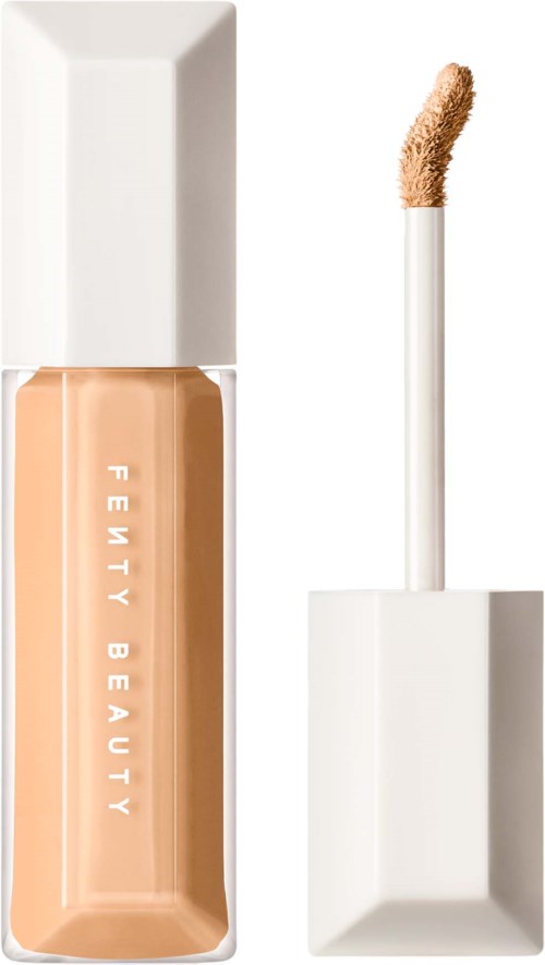 En flaska med flytande concealer med en vit applikatorspets och en vit lock.