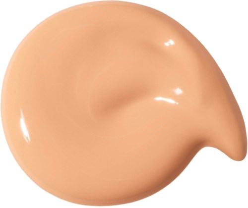 En beige, kurvig klick med flytande foundation som är glänsande.
