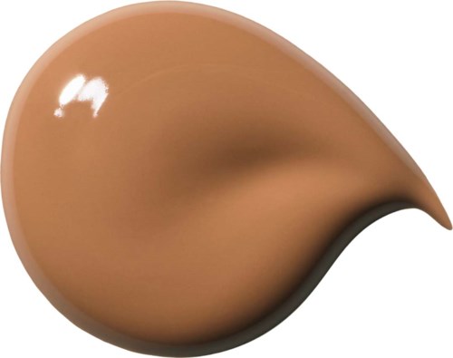 En stor klick av beige sminkgrund med en mörk kant och en ljus reflektion.