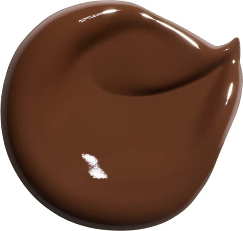 En liten klick av slät chokladsås eller smör, glänsande och brun, med böjda kanter.