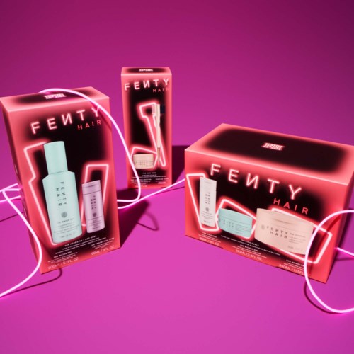 Three hair care product boxes with pink neon lights and a hot pink background. 
