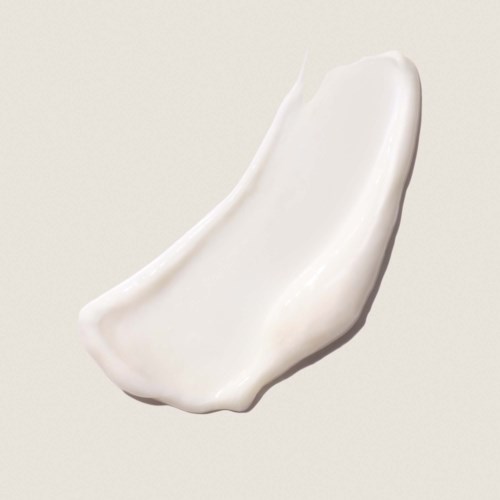 A dollop of white cream or lotion with a smooth, curved shape on a plain background.