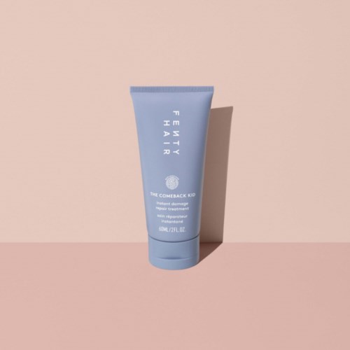 Blue tube with white text, standing on a pink background. It appears to be a skincare or cosmetic product.