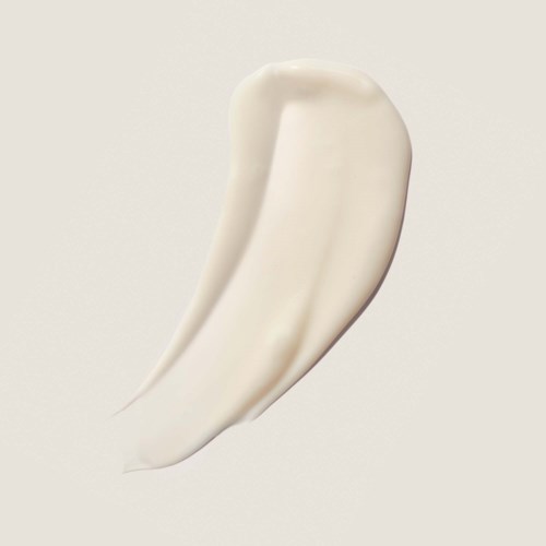 A dollop of white cream or lotion on a plain background.
