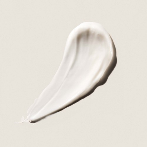 A white cream spread in a curved shape on a light background.