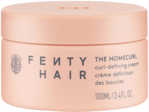 A round peach-colored jar of Fenty Hair curl cream with blue and black text. It says "THE HOMECOURL curl-defining cream."