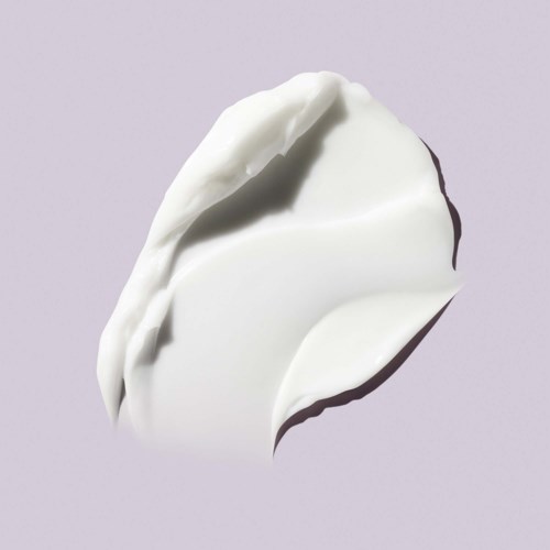 A dollop of white cream or yogurt on a light background, with soft shadows and texture visible.