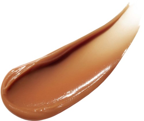 A streak of light brown cream with a glossy texture, smooth and slightly curved.