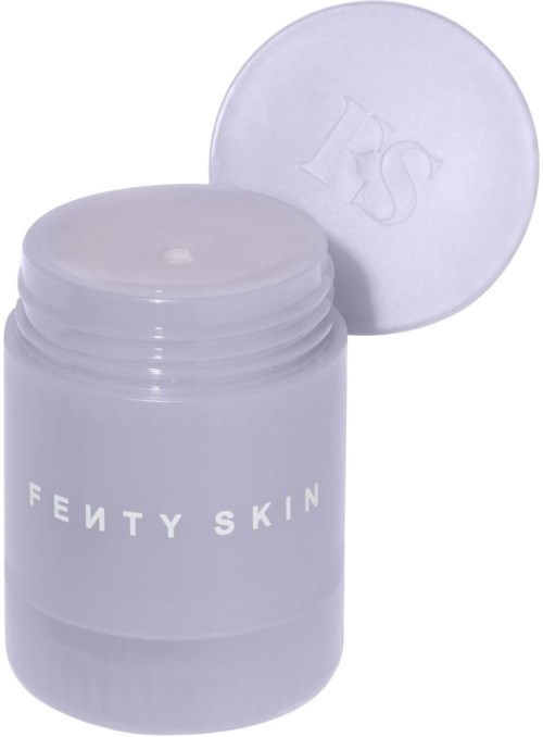 A purple jar of Fenty Skin cream with its lid open, showing the inside. The jar has white text on it.