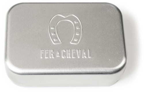 A silver rectangular box with a horseshoe symbol and the word "FER a CHEVAL" on it.