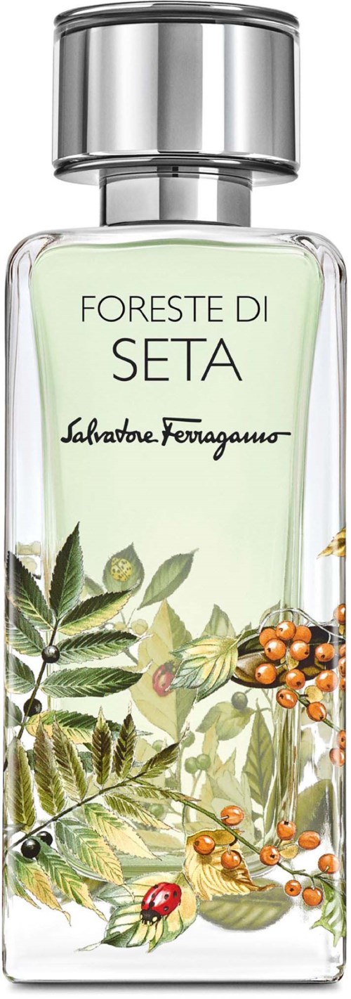 Selkeä hajuvesipullo, jossa on hopeinen kansi, on suunniteltu vihreillä lehdillä ja värikkäillä marjoilla. Etiketti sanoo "Foresta di Seta" ja "Salvatore Ferragamo."